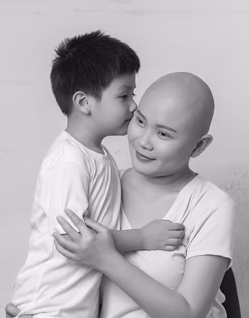 Asian woman who has cancer hugging her son